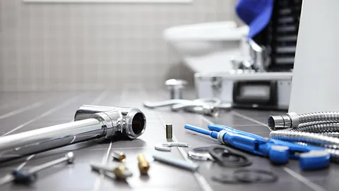 A plumber working in a bathroom